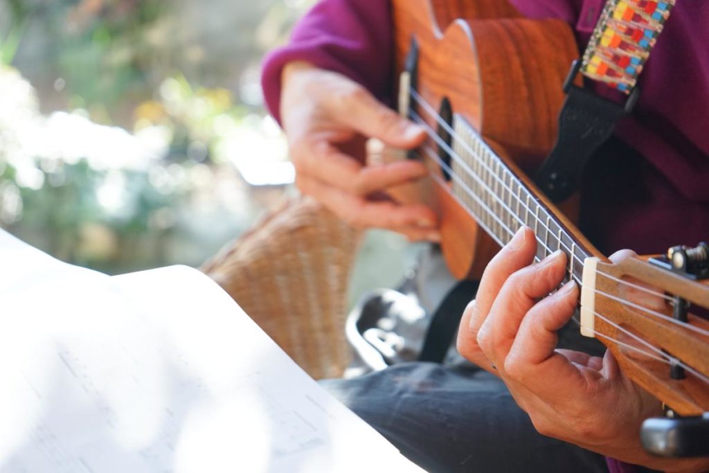 person playing guitar as part of music and recovery