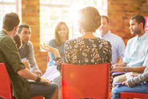 a group of people talk in a circle during a partial hospitalization program san diego