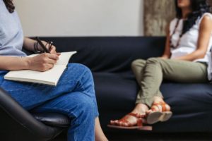 two people talk on a couch in dual diagnosis treatment los angeles