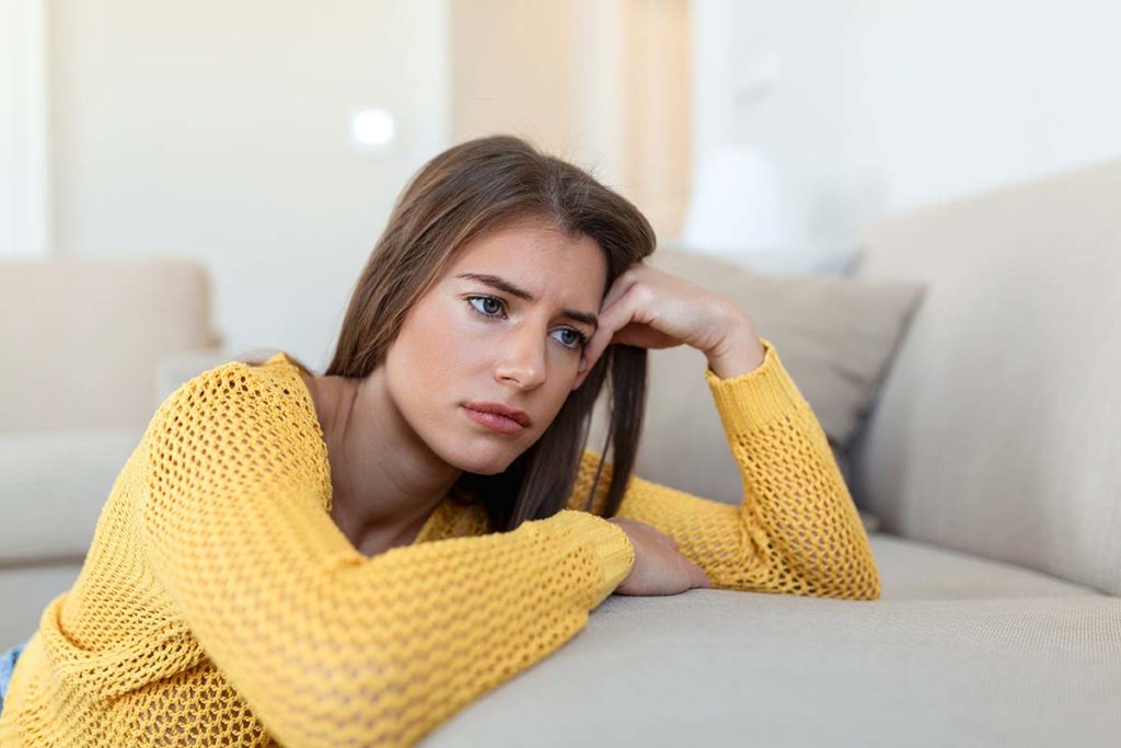 a person looks sad while leaning on a couch experiencing the Mental side effects of suboxone