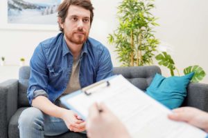 a person sits on a couch at a therapists intake appointment to learn about marijuana dependence treatment