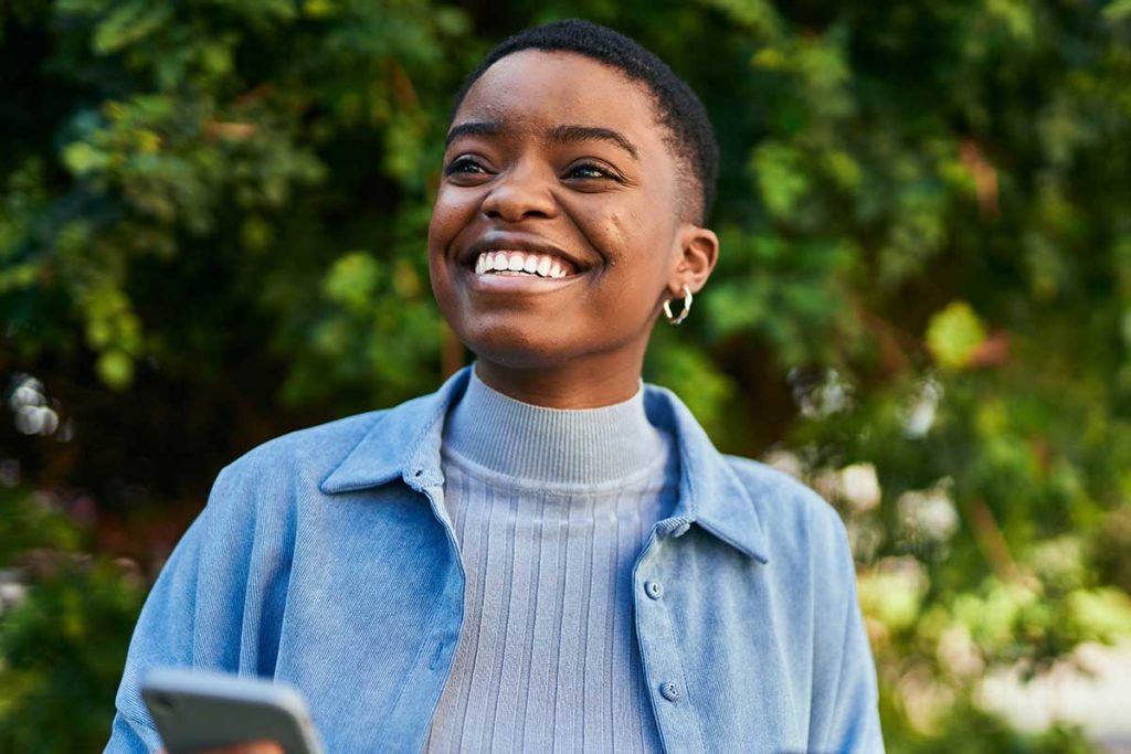 a person smiles outside after learning the benefits of dual diagnosis treatment