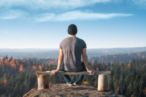 Man sits on bench after hike, after reading up on tips to stay sober