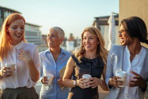 a group of people gather on a rooftop and drink coffee at a residential rehabilitation