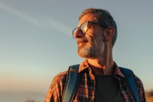 a man smiles outside into a sunset as he is living sober