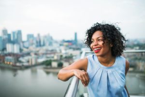 a woman leans against a railing overlooking a city harbor after learning what is php